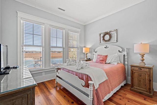 bedroom with crown molding and hardwood / wood-style flooring