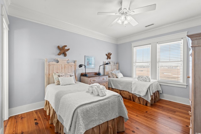 bedroom with hardwood / wood-style flooring, ceiling fan, and crown molding