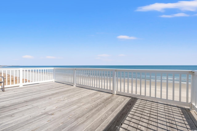 wooden terrace with a water view and a view of the beach