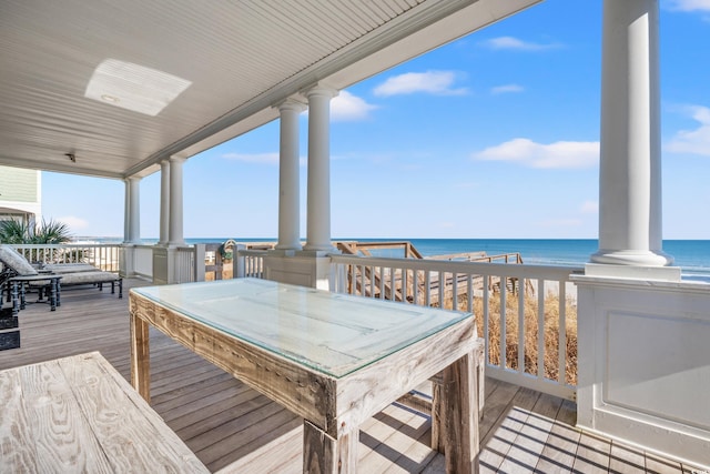 wooden deck with a beach view and a water view