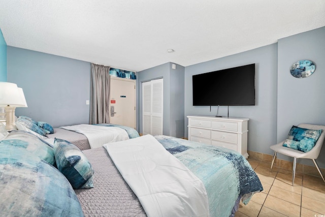 bedroom with a closet and light tile patterned floors