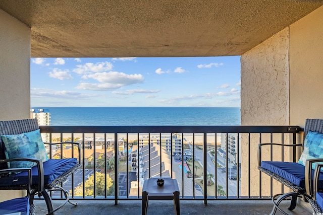 balcony with a water view and a view of the beach