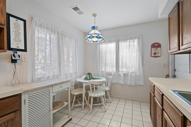 tiled dining space featuring a textured ceiling