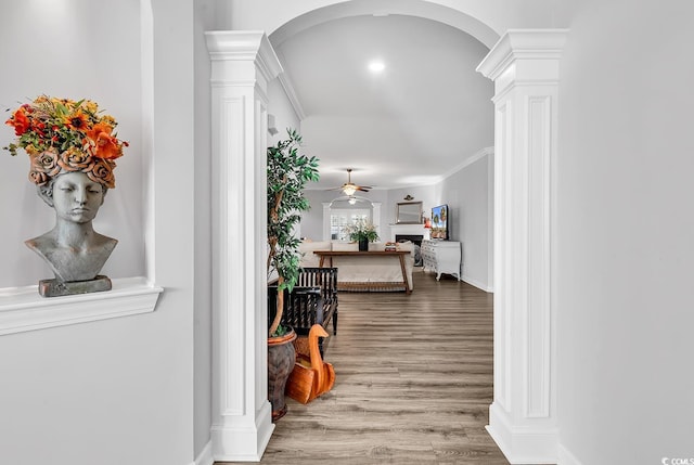 hall with ornamental molding, decorative columns, and wood-type flooring