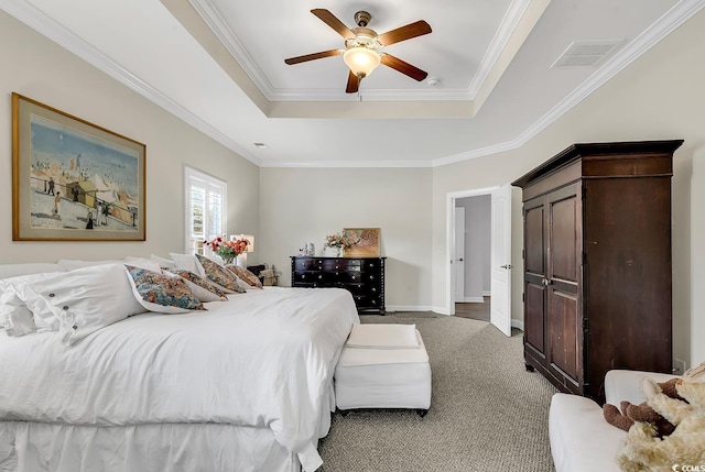 carpeted bedroom featuring ornamental molding, ceiling fan, and a tray ceiling