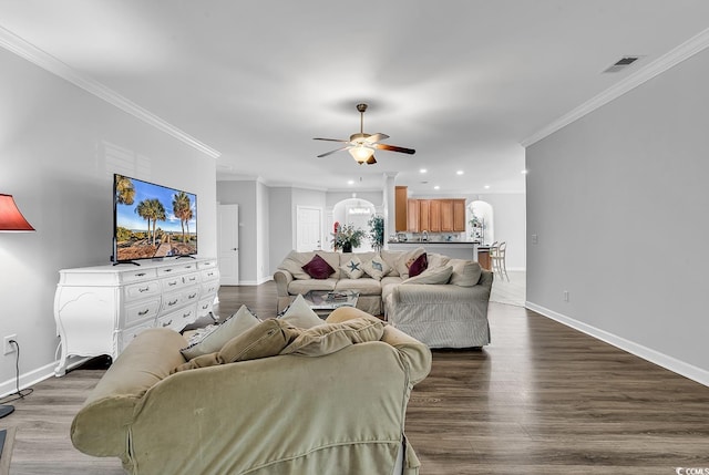 living room featuring wood-type flooring, ceiling fan, and crown molding