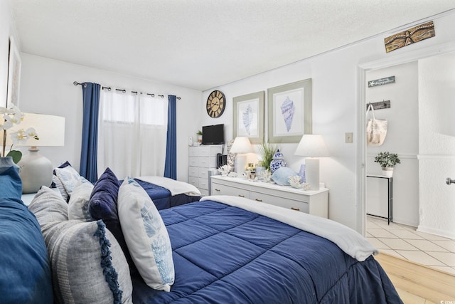 bedroom featuring a textured ceiling and light hardwood / wood-style floors