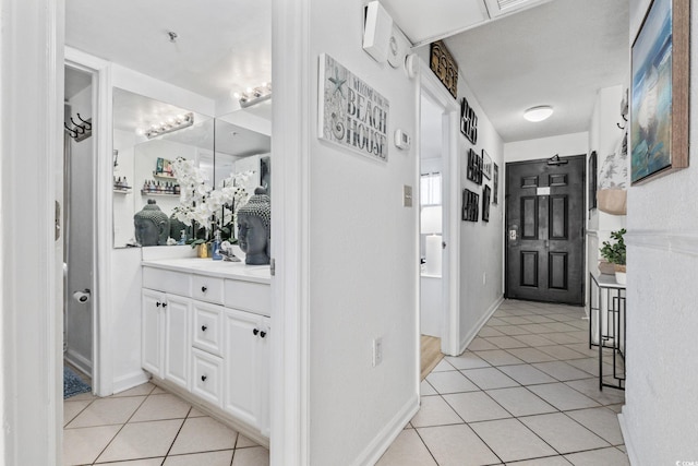 hall with sink and light tile patterned floors