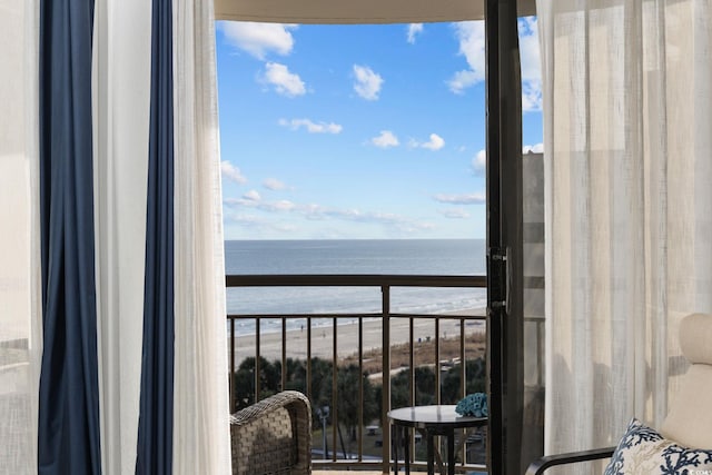 balcony with a water view and a view of the beach