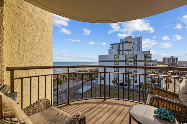 balcony with a water view and a beach view