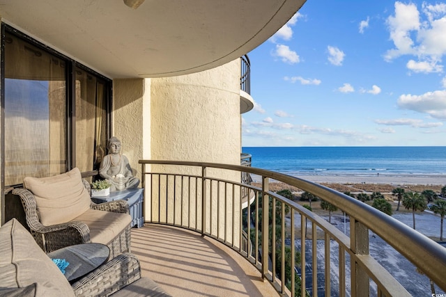 balcony with a water view and a view of the beach