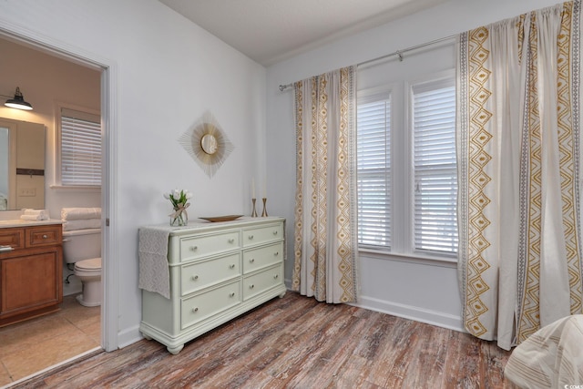 bedroom featuring hardwood / wood-style flooring and ensuite bath