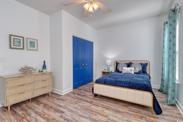 bedroom with hardwood / wood-style floors, ceiling fan, and a closet