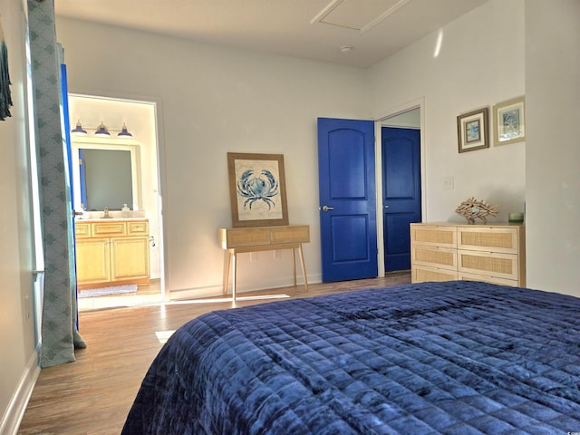 bedroom featuring connected bathroom and light wood-type flooring