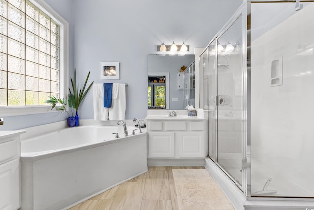 bathroom featuring vanity and shower with separate bathtub