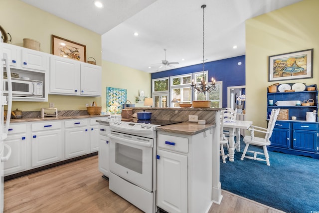 kitchen featuring white cabinets, hanging light fixtures, a center island, white appliances, and light hardwood / wood-style flooring