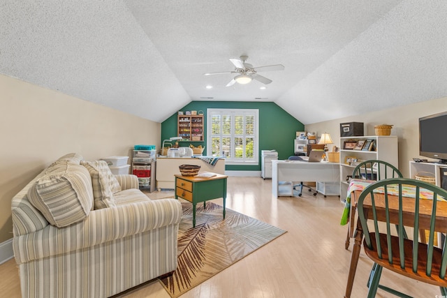 bedroom with vaulted ceiling, ceiling fan, a textured ceiling, and light hardwood / wood-style floors