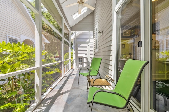 sunroom with ceiling fan, plenty of natural light, and vaulted ceiling