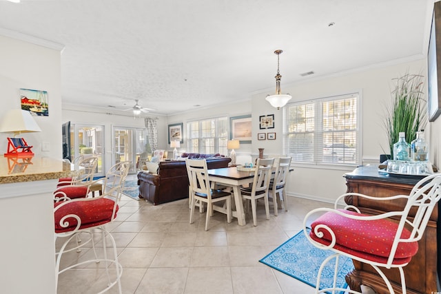 tiled dining area with crown molding, ceiling fan, and a wealth of natural light