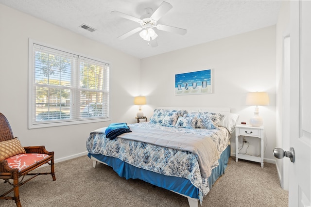 bedroom with a textured ceiling, ceiling fan, and carpet