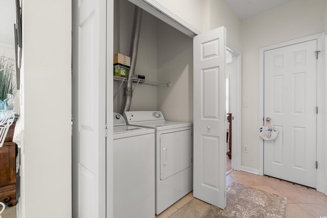 laundry area with light tile patterned floors and washing machine and dryer