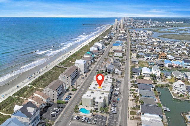 drone / aerial view featuring a water view and a view of the beach