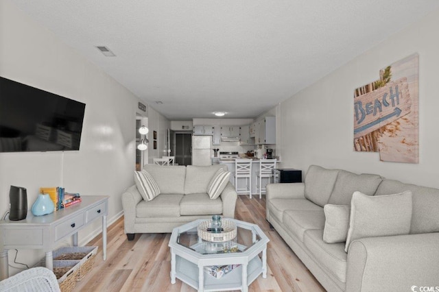 living room featuring visible vents and light wood-style floors