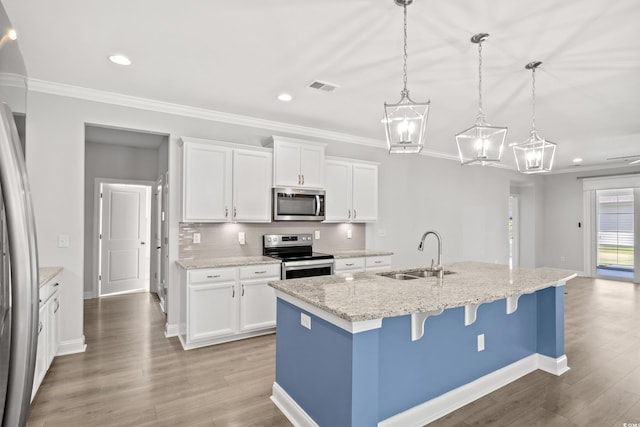 kitchen with sink, white cabinetry, decorative light fixtures, an island with sink, and stainless steel appliances