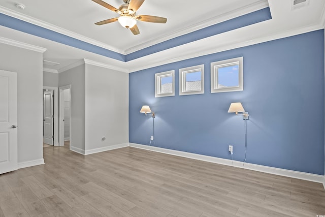 unfurnished room featuring ceiling fan, ornamental molding, a raised ceiling, and light hardwood / wood-style floors