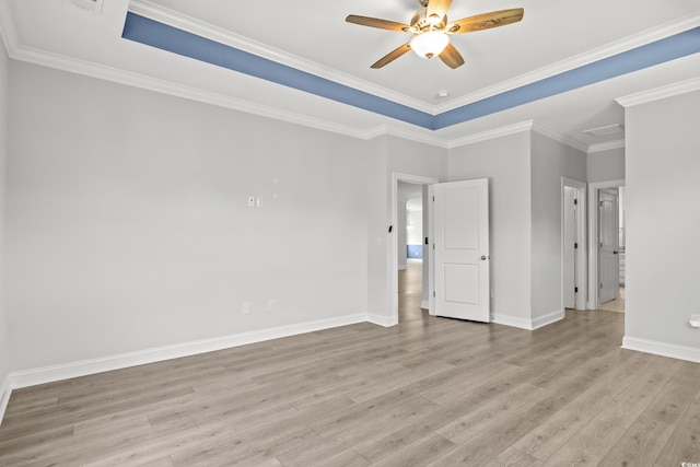 unfurnished room featuring ornamental molding, a raised ceiling, ceiling fan, and light wood-type flooring