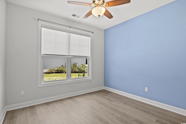 unfurnished room featuring visible vents, a ceiling fan, baseboards, and wood finished floors