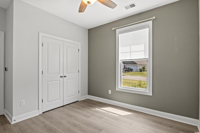 unfurnished bedroom featuring visible vents, baseboards, light wood-style floors, and a closet