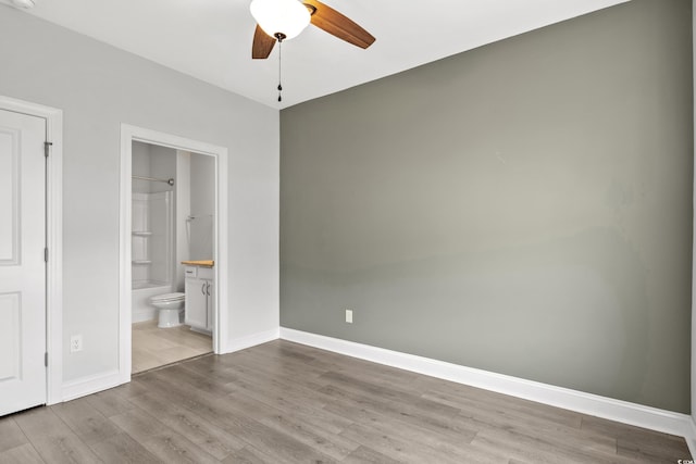 unfurnished bedroom featuring light hardwood / wood-style flooring, ceiling fan, and ensuite bathroom