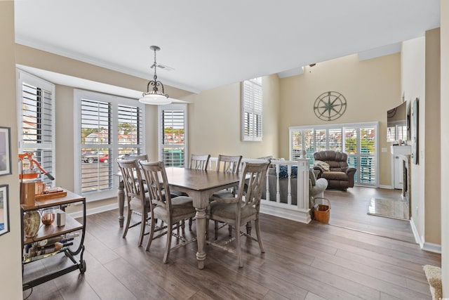 dining space with crown molding and dark wood-type flooring