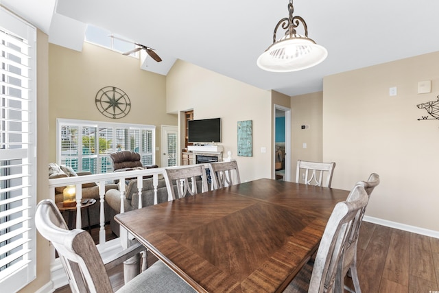 dining room featuring high vaulted ceiling, dark hardwood / wood-style floors, and ceiling fan