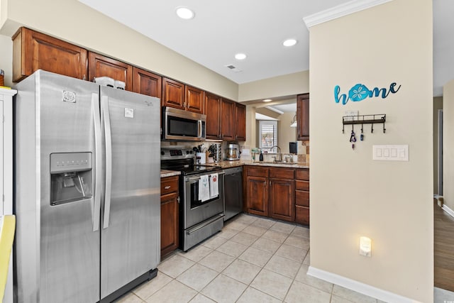 kitchen with light tile patterned floors, stainless steel appliances, sink, and light stone countertops