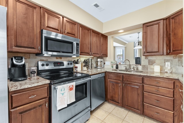 kitchen featuring sink, appliances with stainless steel finishes, light stone countertops, light tile patterned flooring, and decorative backsplash