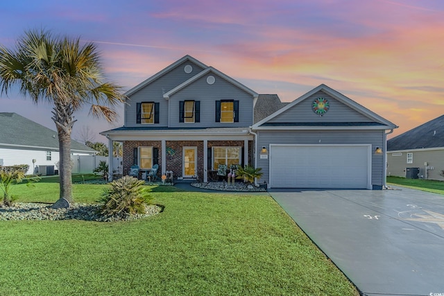 view of front of property with a porch, a yard, central AC unit, and a garage