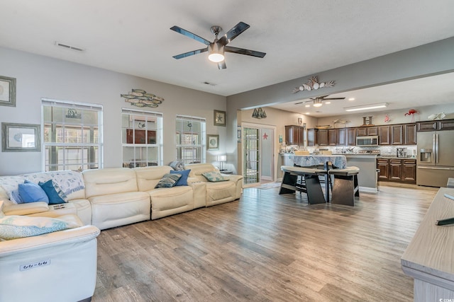 living room with ceiling fan and light hardwood / wood-style flooring