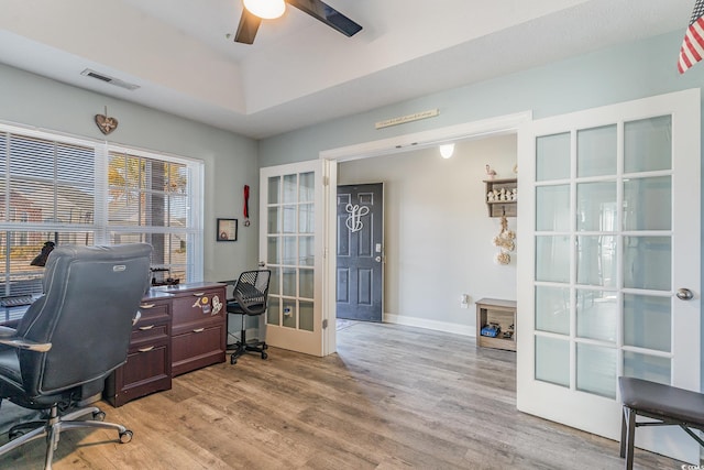 home office featuring french doors, ceiling fan, and light wood-type flooring