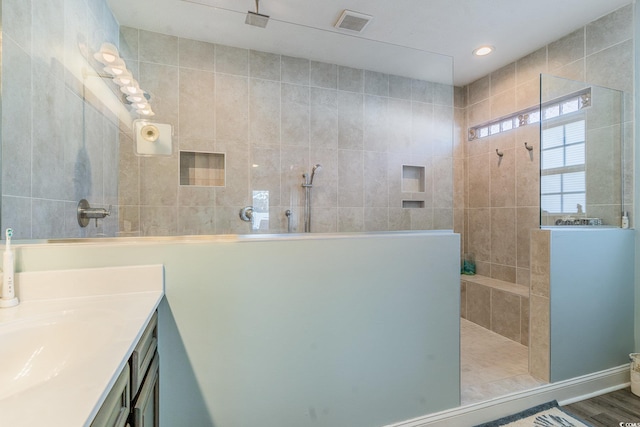 bathroom with vanity and tiled shower