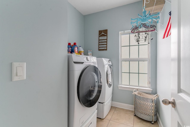 clothes washing area featuring light tile patterned floors and washing machine and clothes dryer