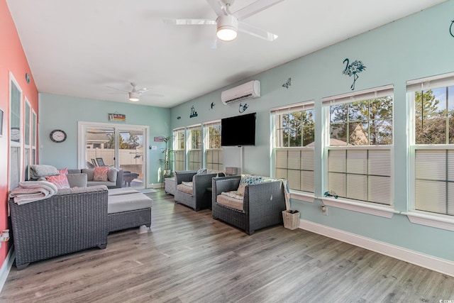 living room featuring a wall mounted AC, ceiling fan, and light hardwood / wood-style floors