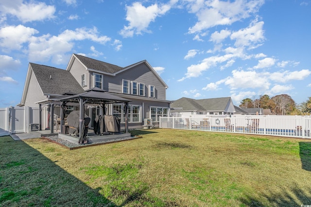 back of property with a pool, a gazebo, and a lawn