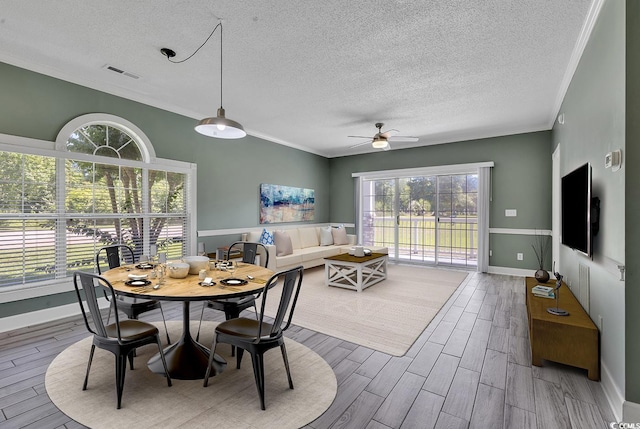 dining room featuring crown molding, ceiling fan, and a textured ceiling