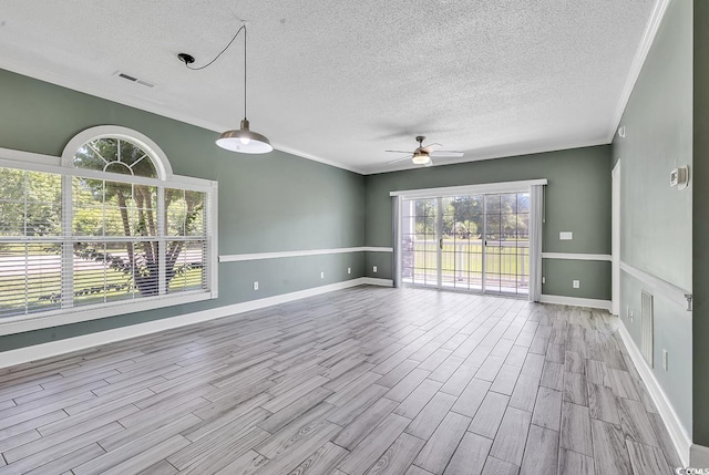 spare room with ceiling fan, ornamental molding, a textured ceiling, and light wood-type flooring