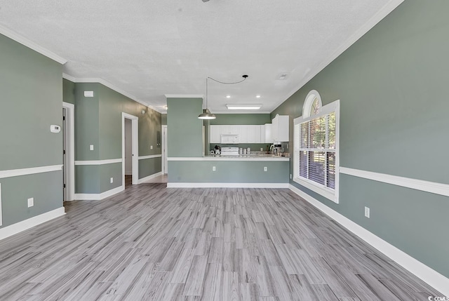 unfurnished living room featuring ornamental molding, a textured ceiling, and light hardwood / wood-style flooring