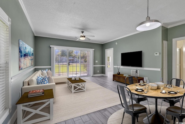 living room featuring wood-type flooring, ornamental molding, and ceiling fan