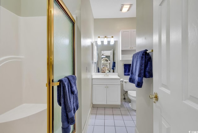 bathroom featuring vanity, a shower with shower door, and tile patterned floors