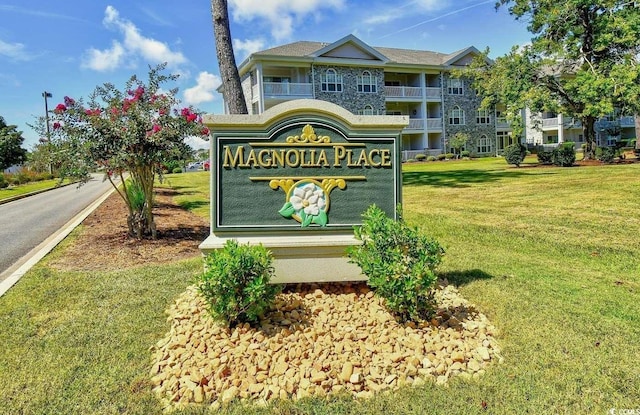 community sign featuring a lawn